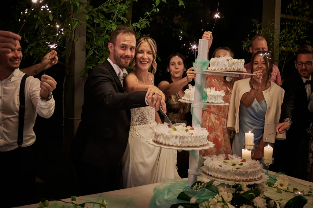 sposi durante taglio della torta nuziale