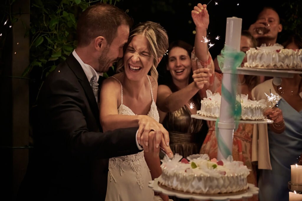 sposi durante taglio della torta nuziale